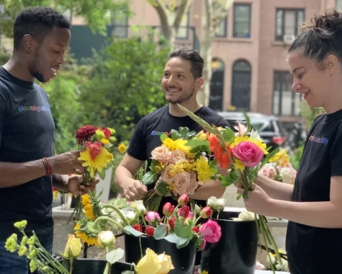 A group of people standing around a table with flowers.