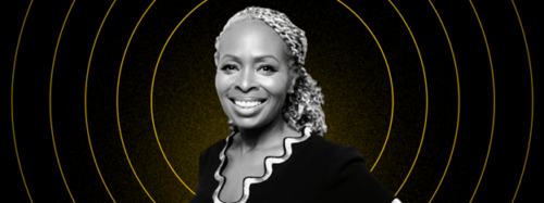 A Black woman smiling in front of a yellow and black background.