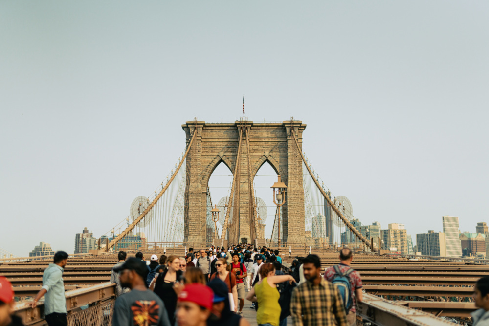 View of the Brooklyn Bridge showing a crowd of people walking across.