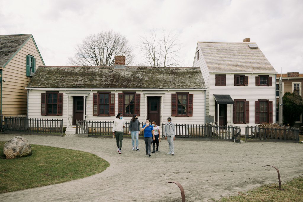 A group of people walking in front of a house.