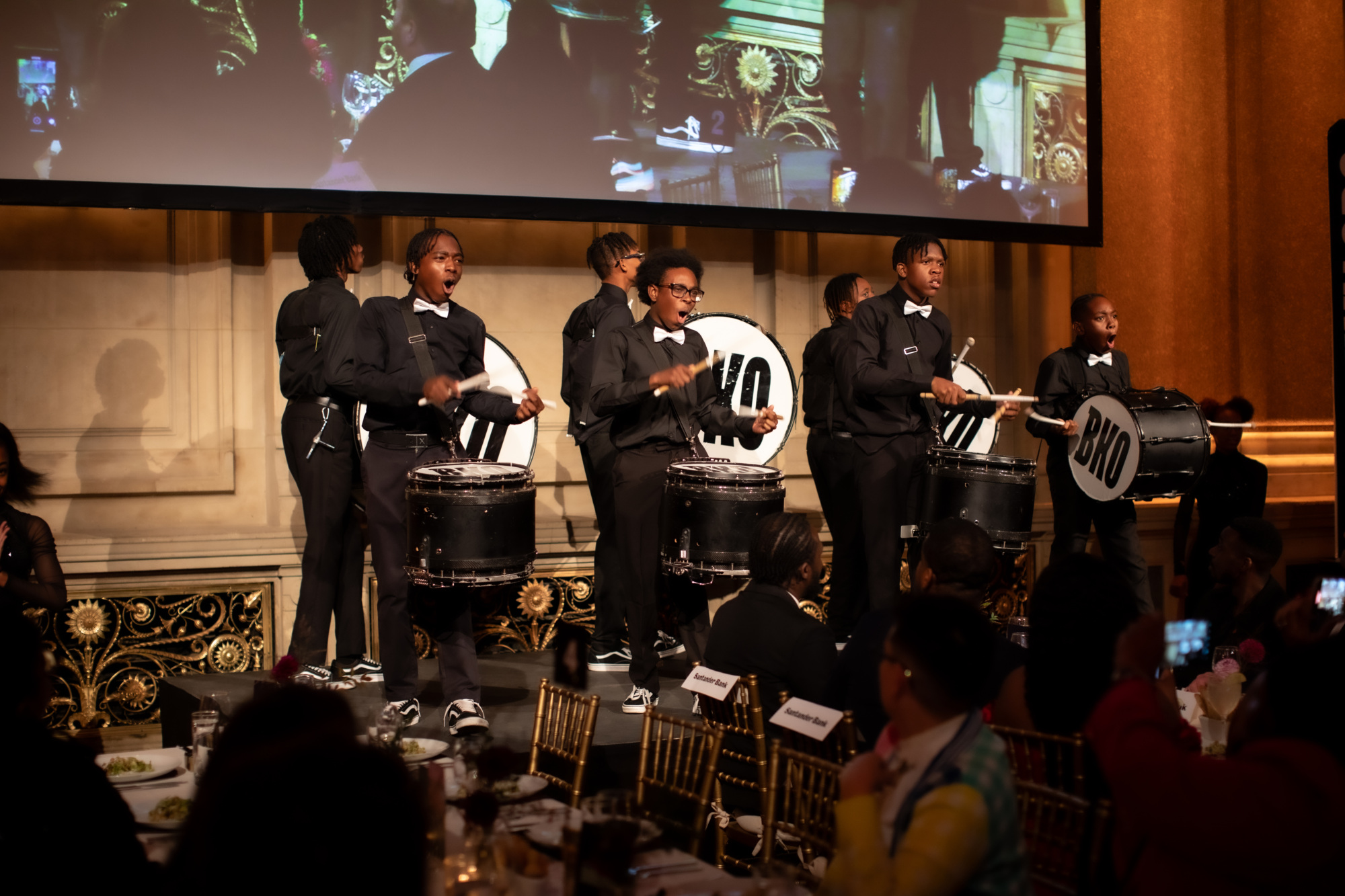 A group of men in tuxedos playing drums.