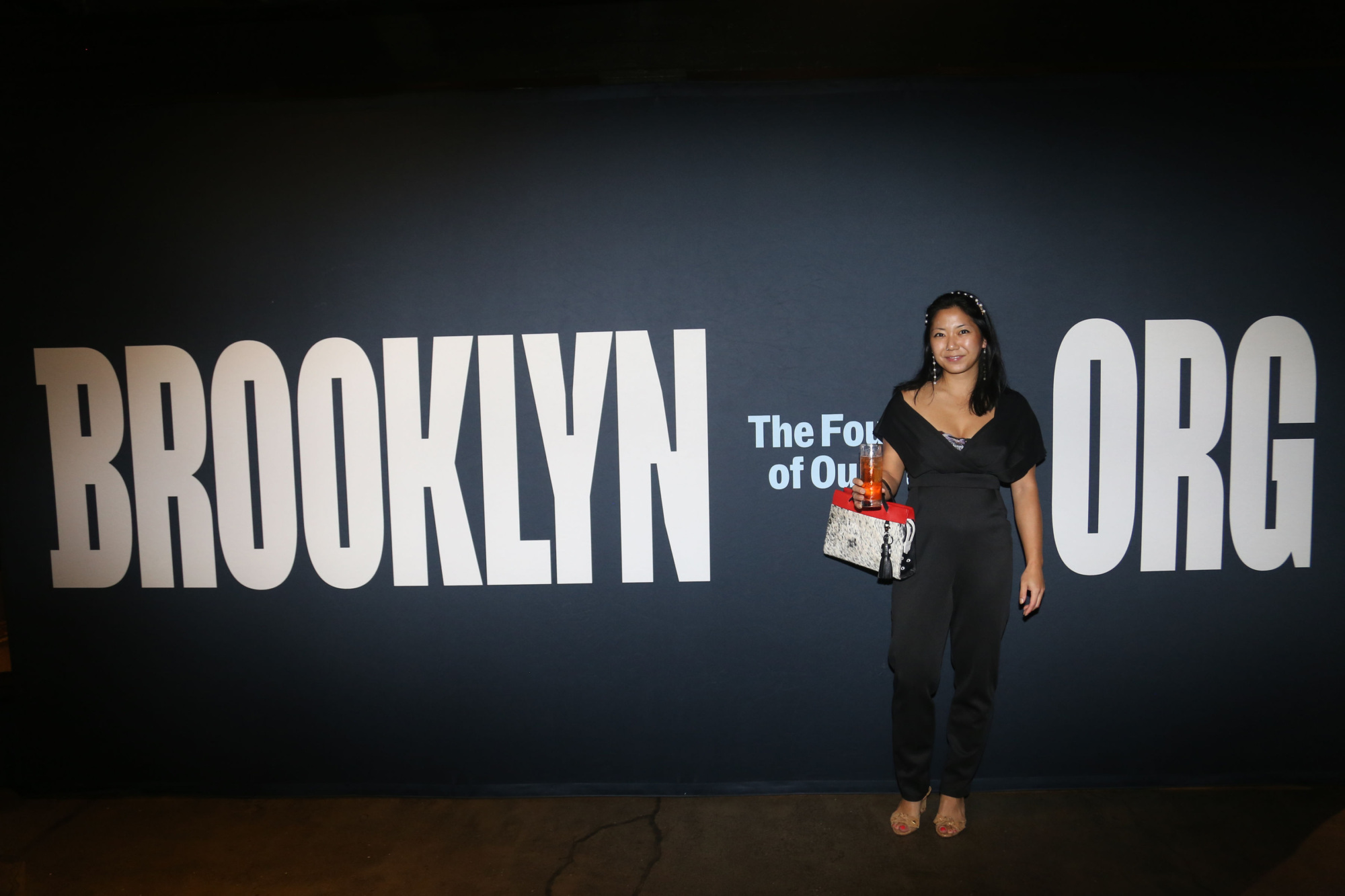 A woman standing in front of the brooklyn org sign.