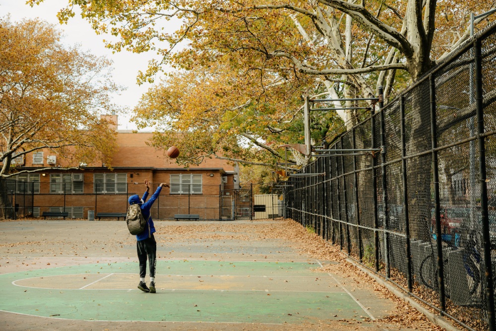A person is throwing a basketball on a basketball court.