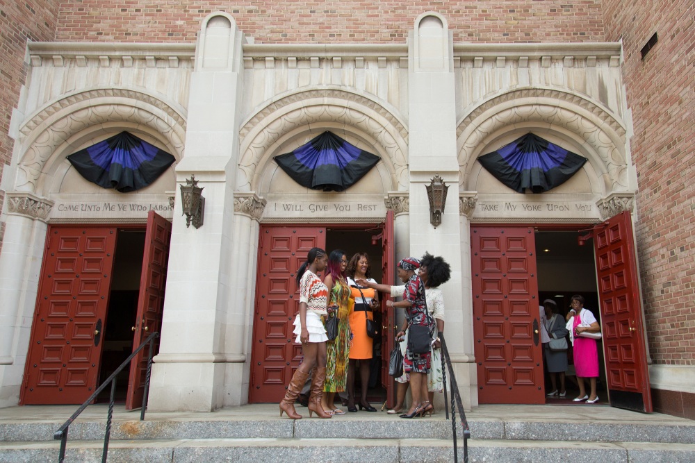 A group of women standing outside of a church.