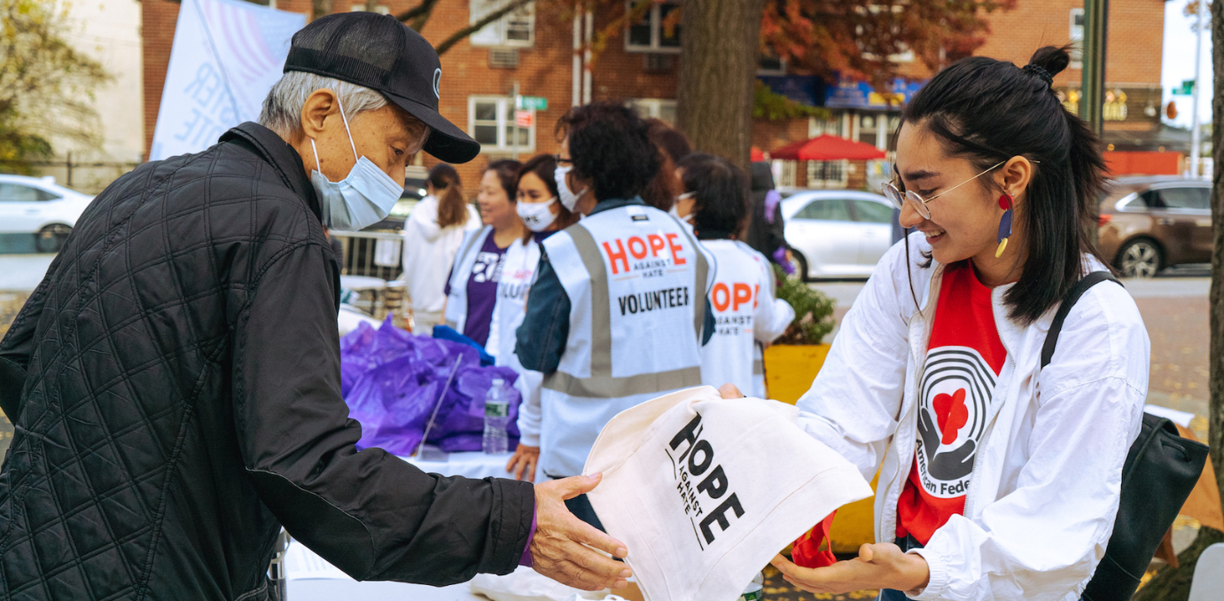 A woman is shaking hands with a man wearing a mask.