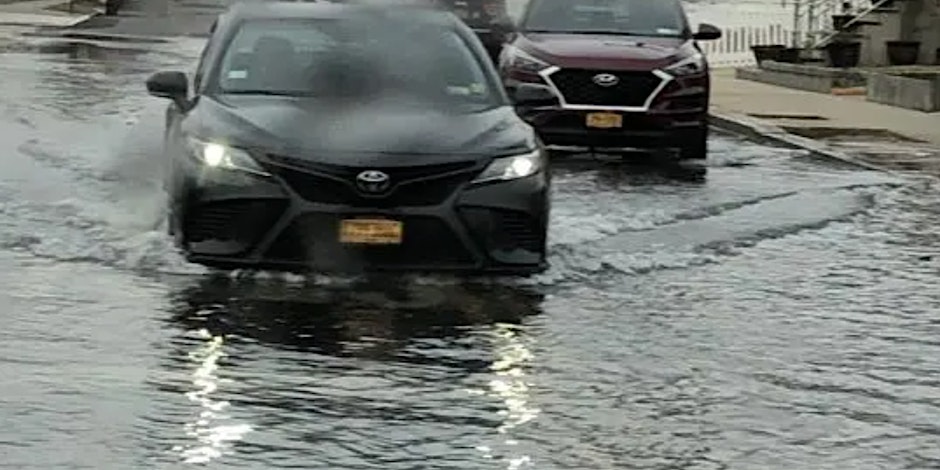 A car driving down a flooded street.