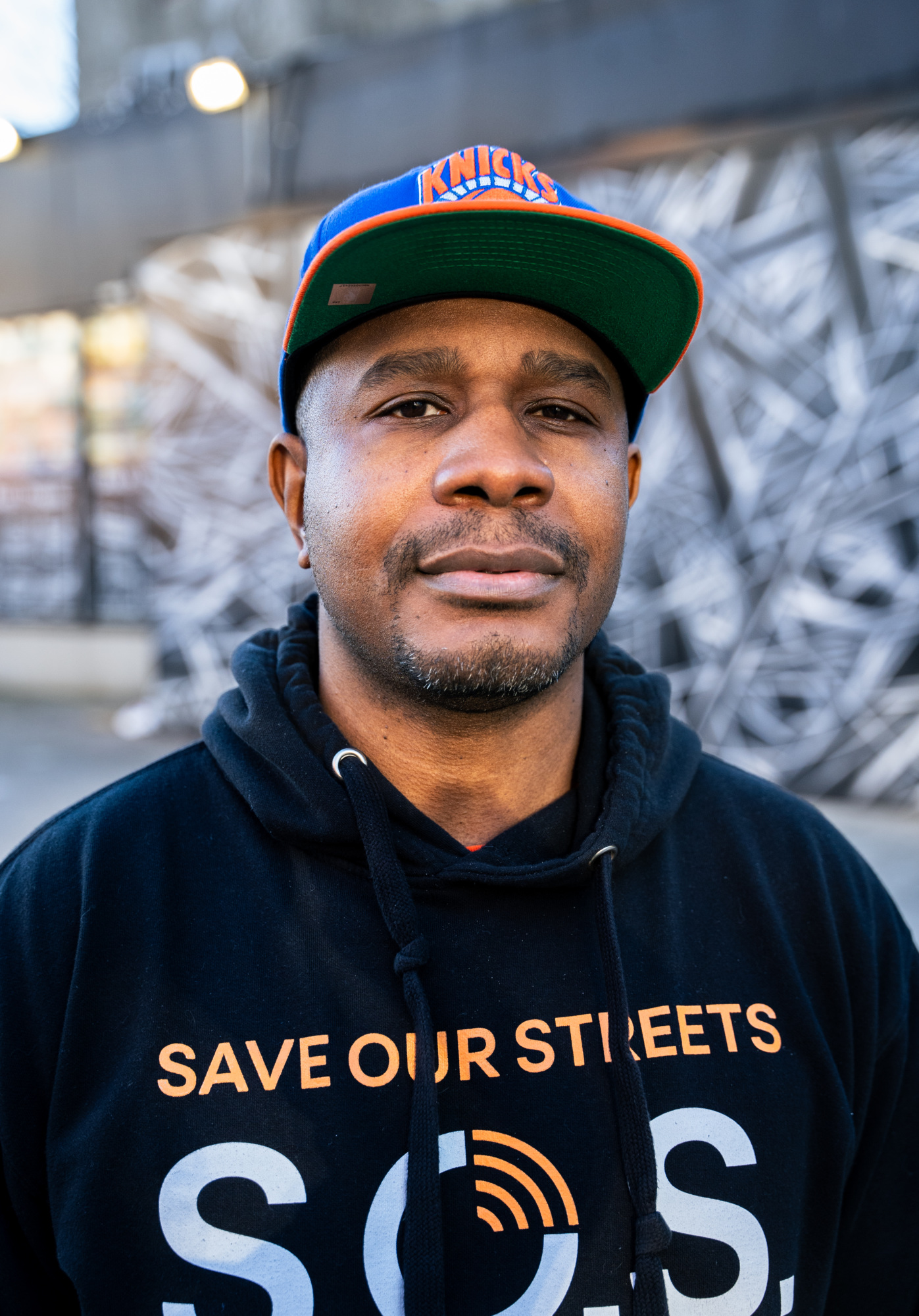 A man wearing a hoodie with the words save our streets.