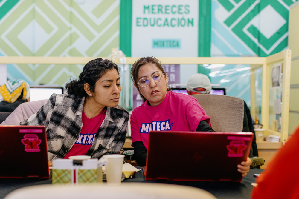 Two women working on laptops in an office.