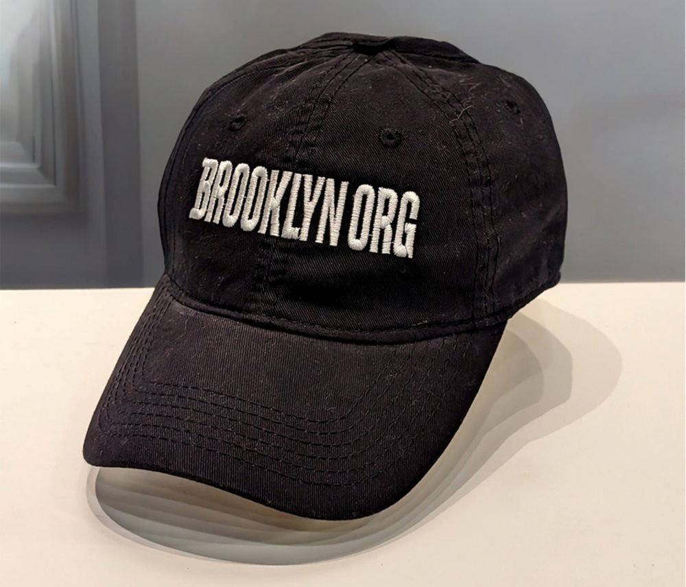 A worn black baseball cap with "brooklyn.org" embroidered in white letters.