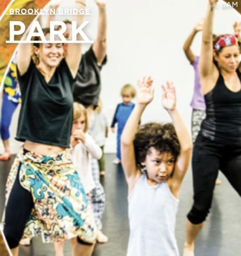 A diverse group of people, including adults and a child, participating in a dance class at brooklyn bridge park.