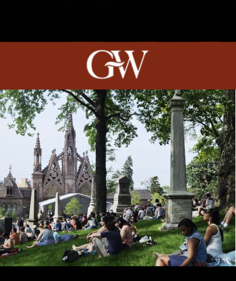 Students sitting on grass at a university campus, with a gothic-style building in the background and a logo reading "gw" at the top.
