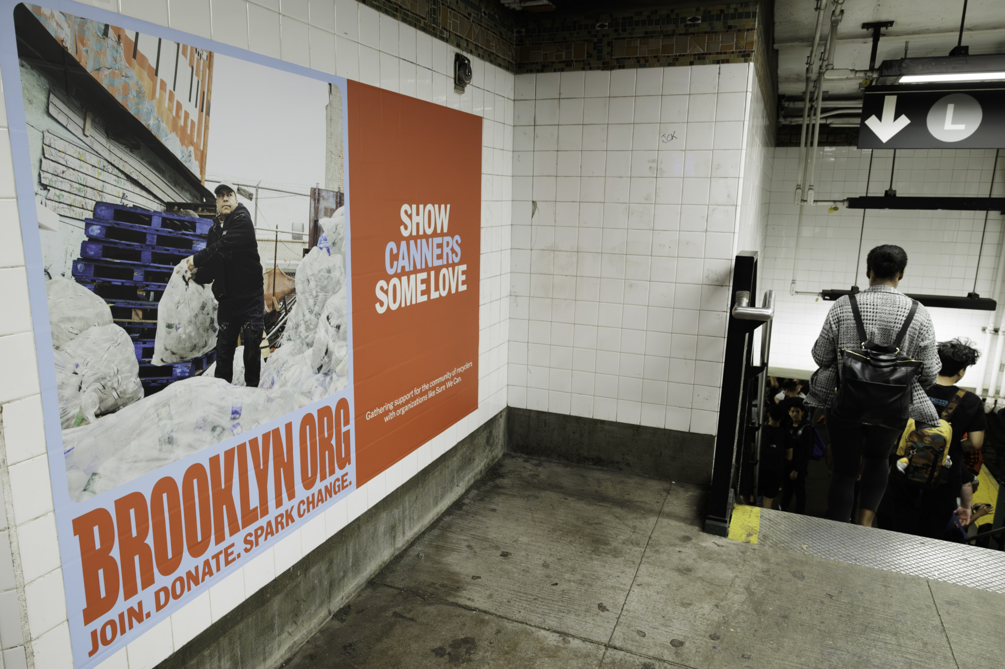 A large poster on a subway wall promotes Brooklyn.org's campaign to support canners. Nearby, commuters descend stairs towards the train platform.