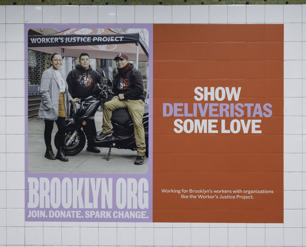 A poster on a tiled wall in a subway station reads, "BROOKLYN.ORG JOIN. DONATE. SPARK CHANGE," with an image of delivery workers. Text next to it says, "SHOW DELIVERISTAS SOME LOVE - GIVE TO BROOKLYN.