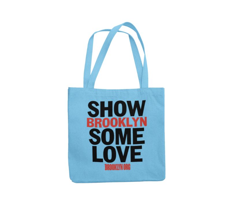 A light blue tote bag with the text "SHOW BROOKLYN SOME LOVE" in black and red letters. The website "BROOKLYN.ORG" is printed at the bottom in red.