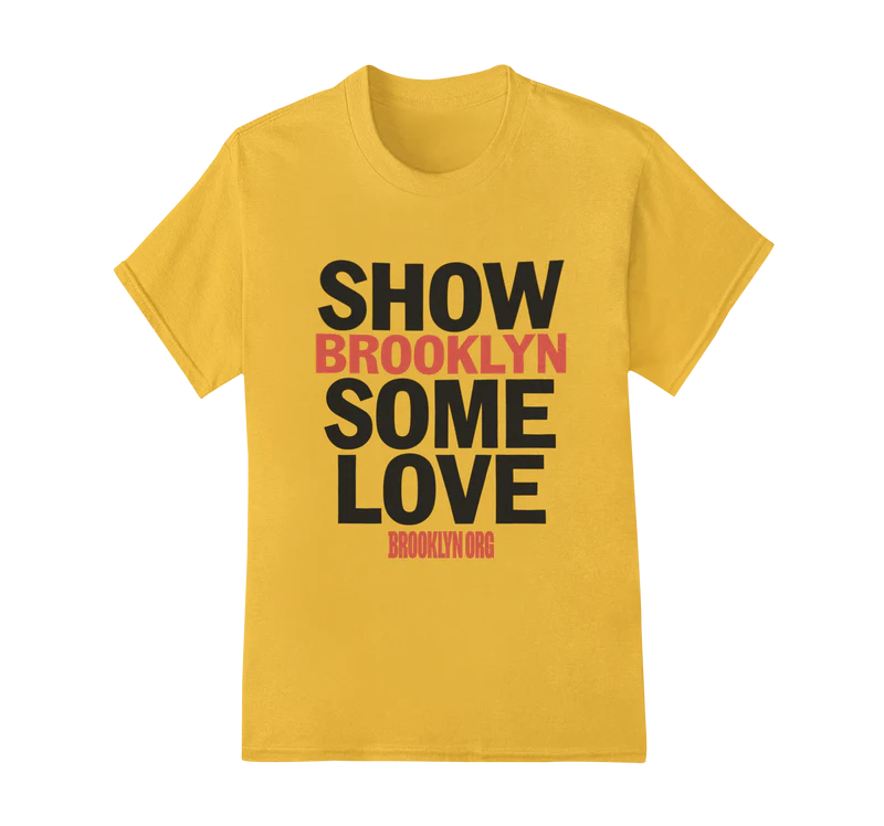 A yellow T-shirt with the text "SHOW BROOKLYN SOME LOVE" in large black and red letters, and "BROOKLYN.ORG" in small red letters at the bottom.
