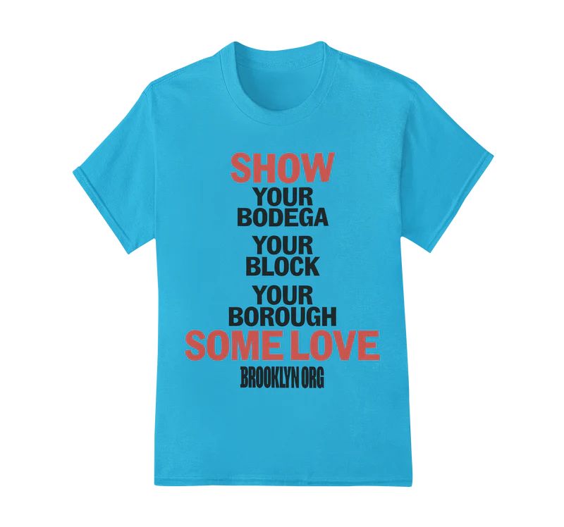 A blue T-shirt with the text "SHOW YOUR BODEGA YOUR BLOCK YOUR BOROUGH SOME LOVE" in red and black font, followed by "BROOKLYN ORG" at the bottom.