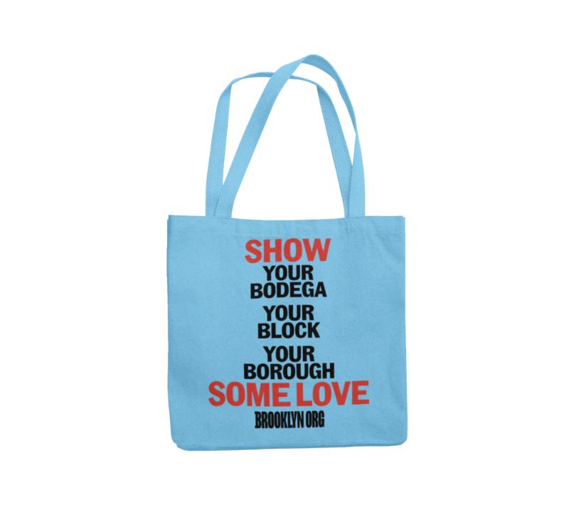 Light blue tote bag with text: "SHOW YOUR BODEGA YOUR BLOCK YOUR BOROUGH SOME LOVE" in black and red, followed by "BROOKLYN ORG" in black.