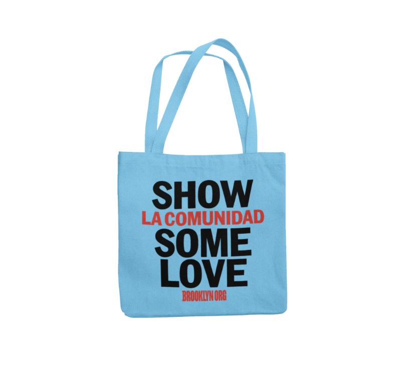 Light blue tote bag with the text "Show La Comunidad Some Love Brooklyn.org" printed in black and red.