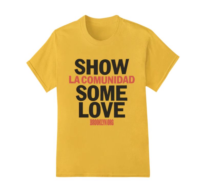 Gold T-shirt with the text "Show la comunidad some love" in large font and "Brooklyn Org" in smaller font.