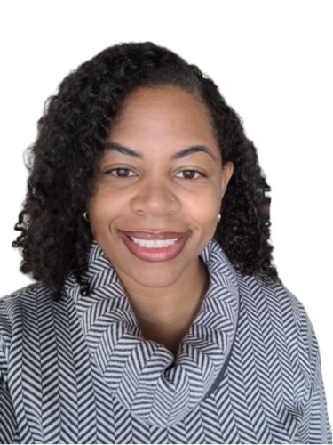 Portrait of a person smiling, wearing a black and white patterned jacket.