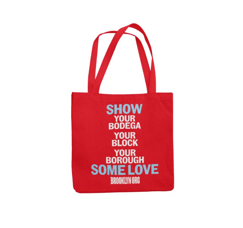 Red tote bag with text: "SHOW YOUR BODEGA YOUR BLOCK YOUR BOROUGH SOME LOVE" in white and blue, followed by "BROOKLYN ORG" in white.