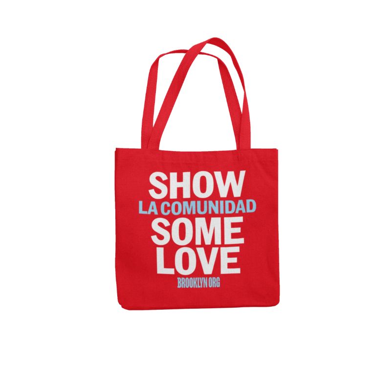 Red tote bag with the text "Show La Comunidad Some Love Brooklyn Org" printed in white and blue.