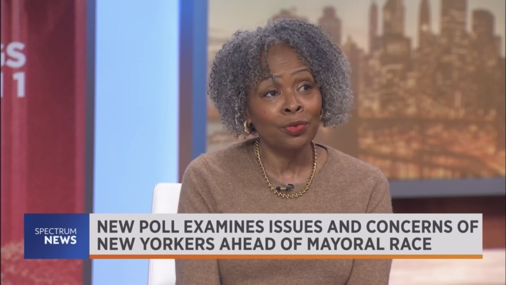 A woman with curly gray hair sits in a TV studio. The overlay text reads, "New poll examines issues and concerns of New Yorkers ahead of mayoral race.