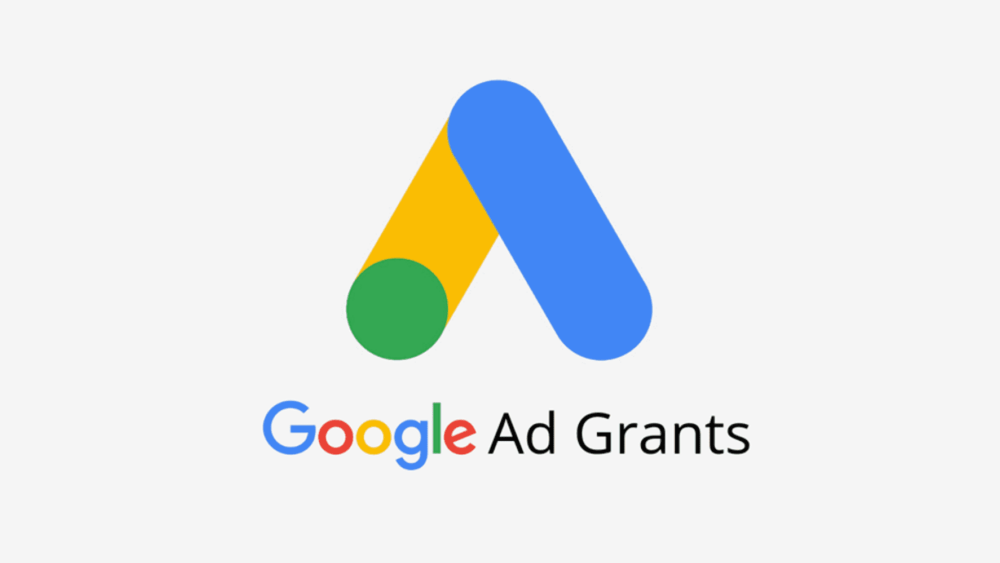Google Ad Grants logo featuring the Google Ads icon above the text "Google Ad Grants" on a light gray background.