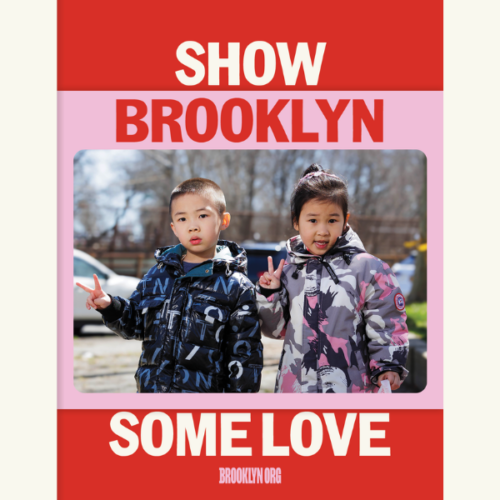 Two children in patterned jackets stand outdoors, both making peace signs, with a “Show Brooklyn Some Love” message framed around the image.