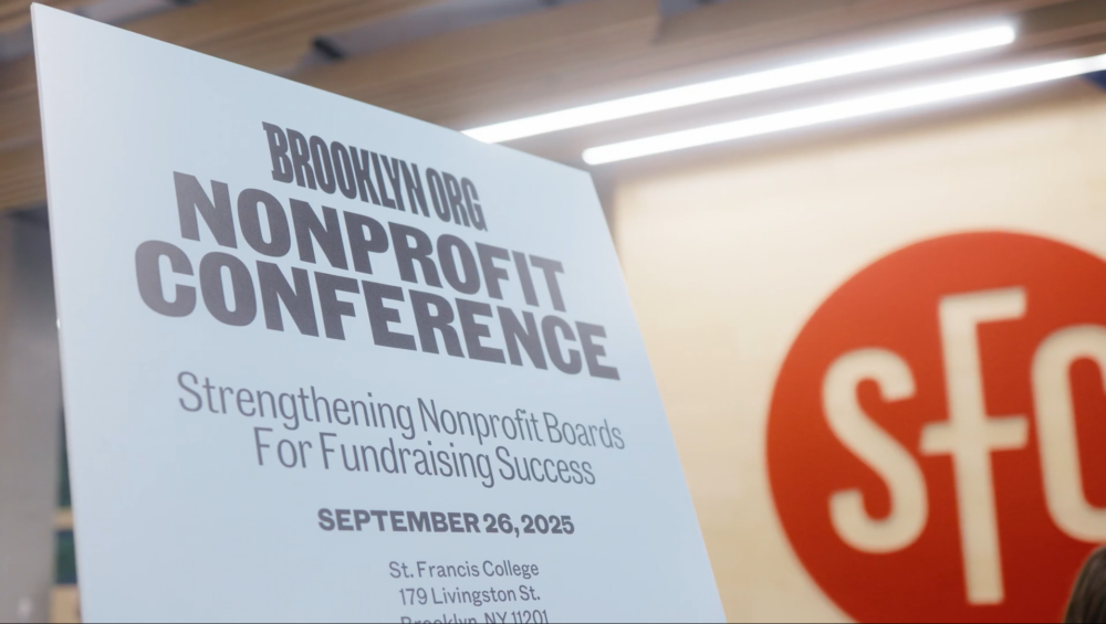 A sign reads "Brooklyn.org Nonprofit Conference: Strengthening Nonprofit Boards For Fundraising Success," with event details and date September 26, 2025, at St. Francis College.