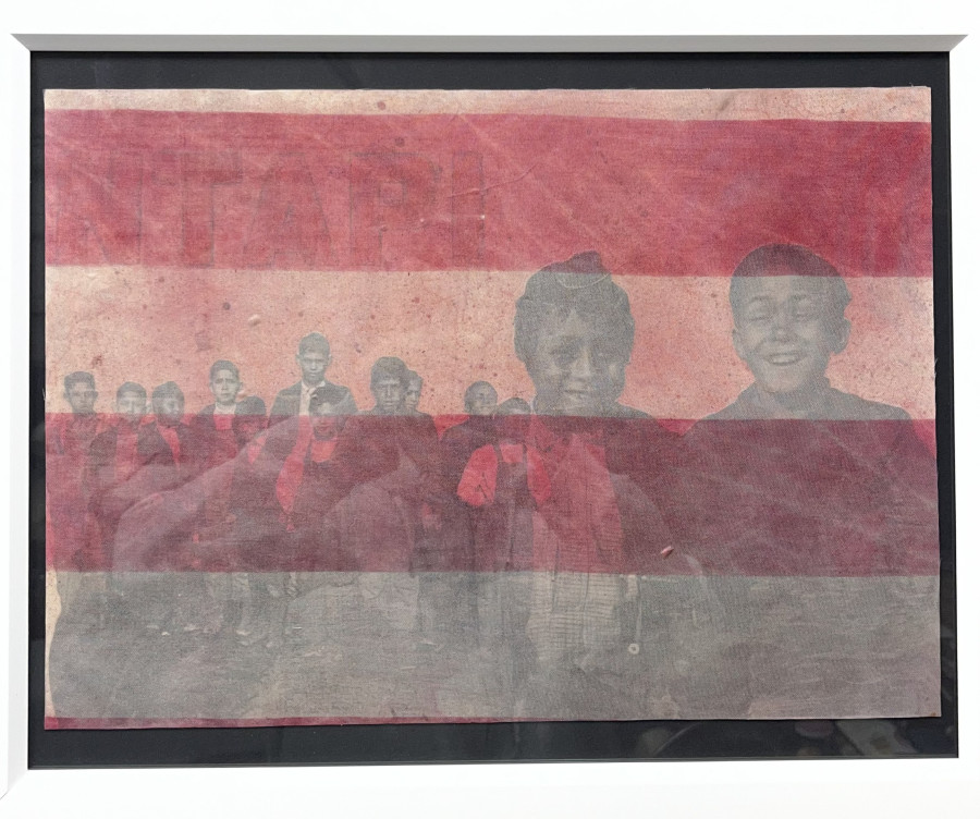 A group of children stands together, overlaid with faded horizontal red stripes and partially obscured text, inside a white-framed image.