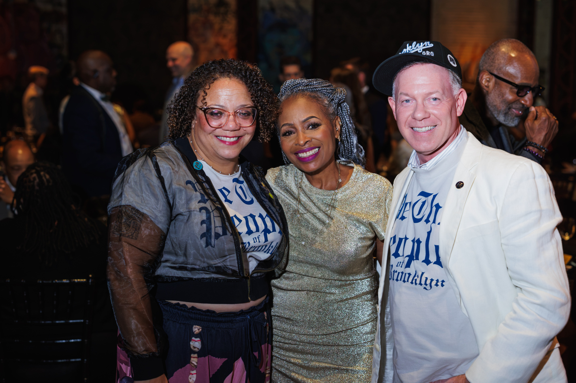 Three people smiling and posing for a photo at an event.