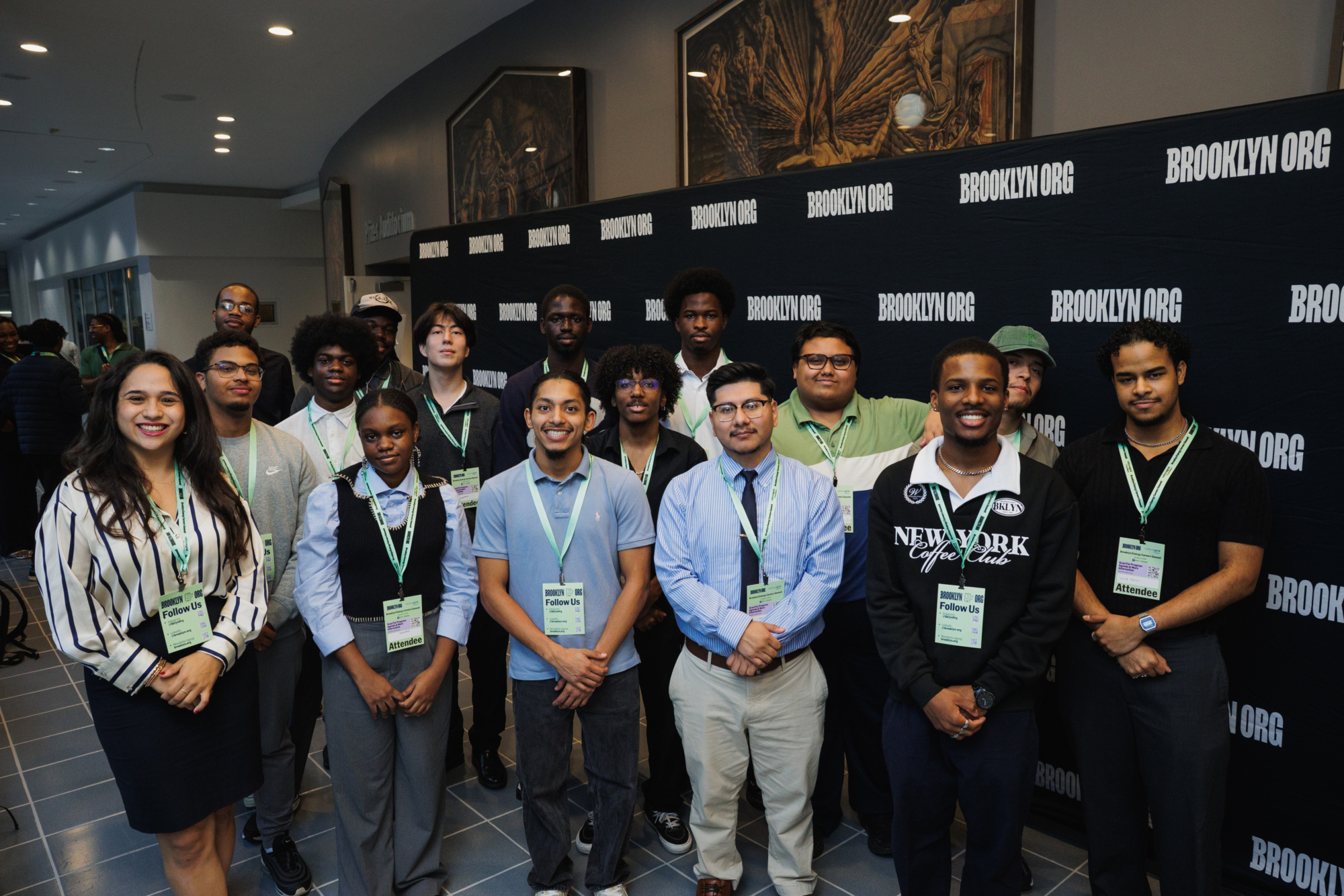 A group of people wearing conference badges pose in front of a black step-and-repeat backdrop featuring the “BROOKLYN ORG” logo.