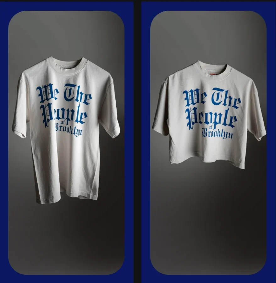 Two off-white t-shirts side-by-side, each featuring the blue text “We The People of Brooklyn” in a gothic font; one is standard length and the other is cropped.