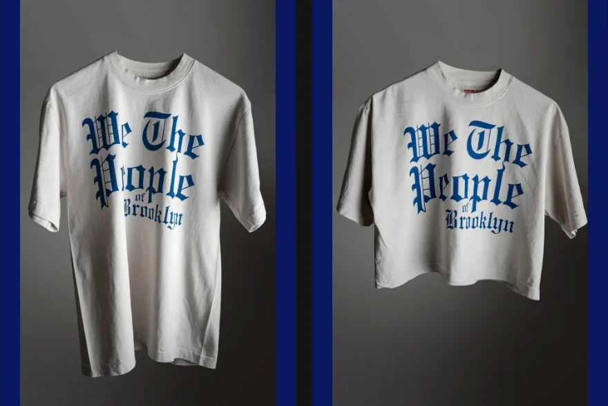 Off-white t-shirt and cropped t-shirt, both featuring the blue text “We The People of Brooklyn” in gothic font.